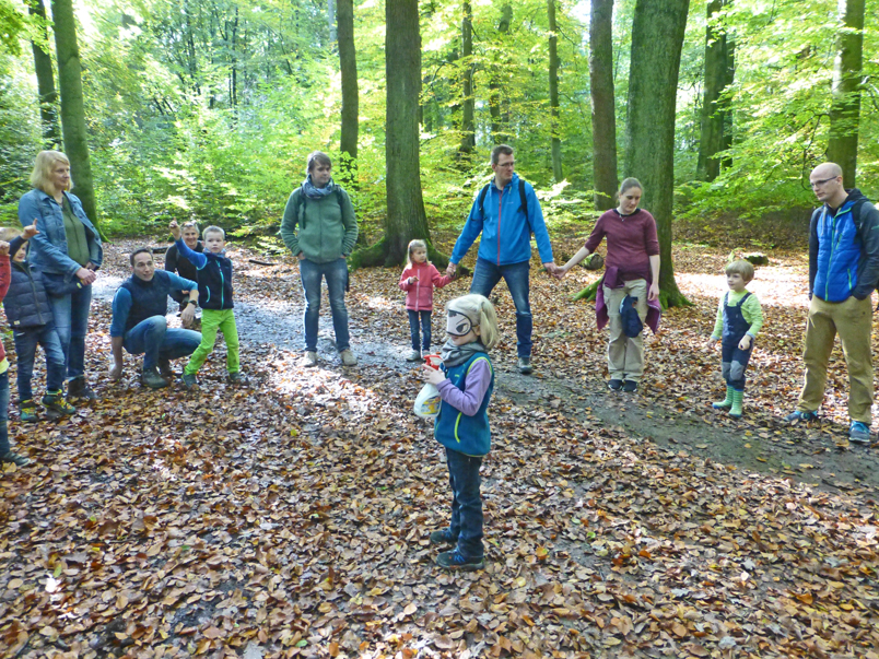 Eltern und Kinder beim Spiel im Wald