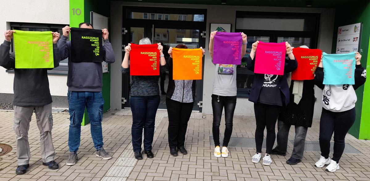 Gruppenfoto mit bunten Anti-Rassismus-Taschen